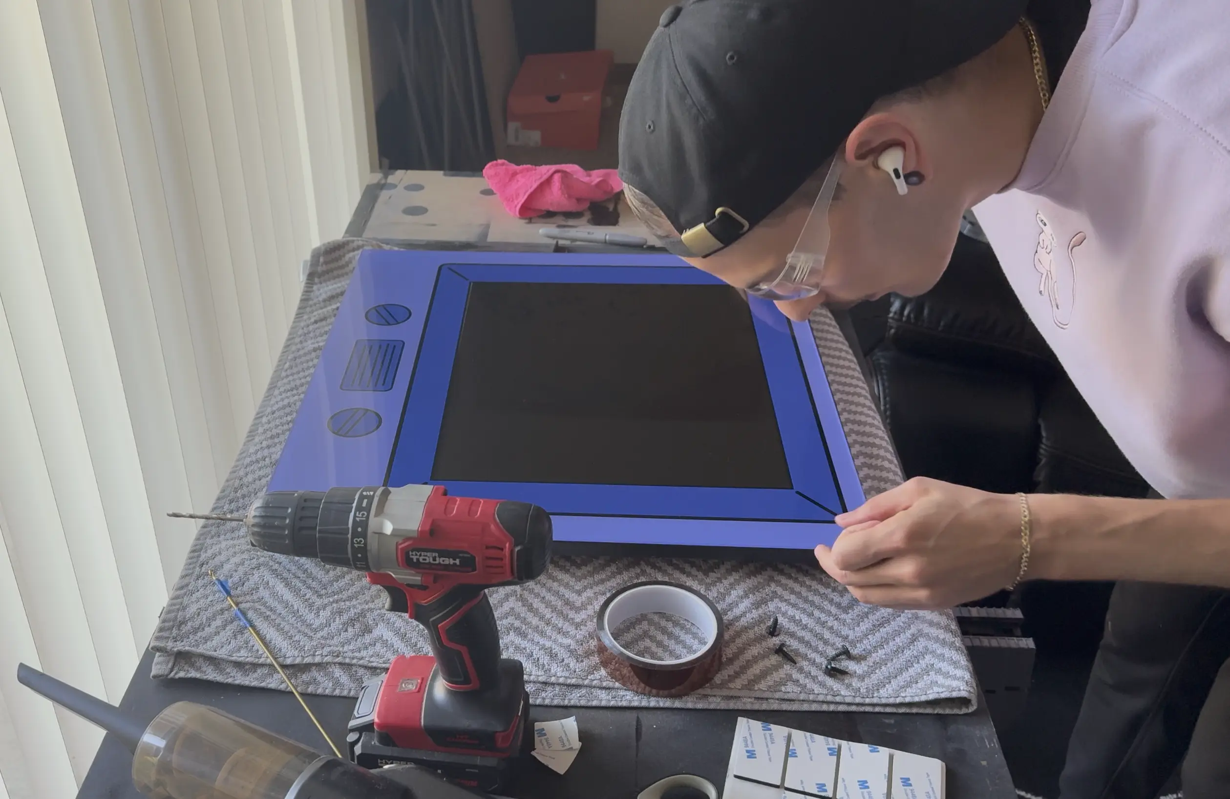 Installing the bezel acrylic on top of the monitor assembly.